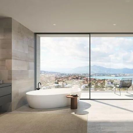 Bathroom behind a Schüco AS PD 75.HI panoramic sliding wall with a coastal view